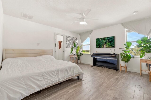 1909 Cayman Cove Cir, Saint Cloud, FL 34772 - bedroom featuring a textured ceiling, light wood-type flooring, baseboards, visible vents, and a ceiling fan