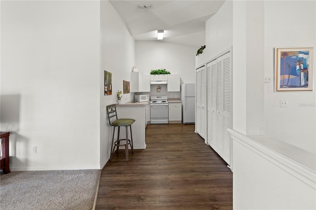 corridor with lofted ceiling and dark hardwood / wood-style floors