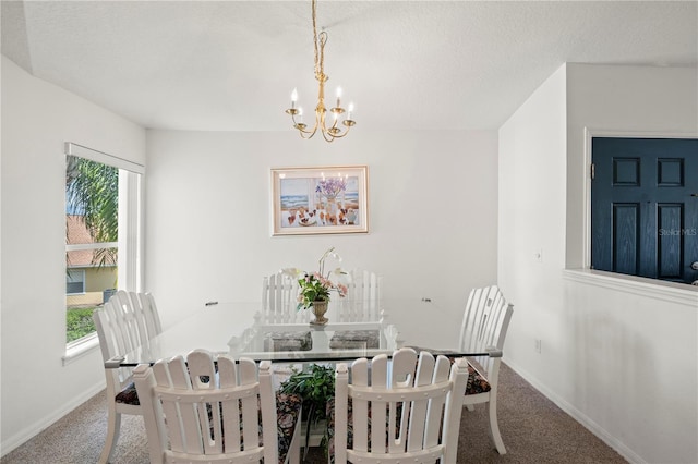 carpeted dining room with a notable chandelier and a textured ceiling