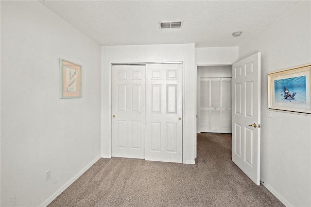 unfurnished bedroom with carpet floors, a closet, and a textured ceiling