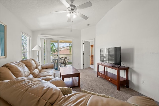 living room featuring lofted ceiling, ceiling fan, light carpet, and a textured ceiling