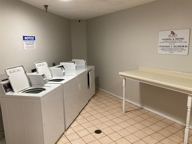 laundry area with light tile patterned floors and washer and clothes dryer