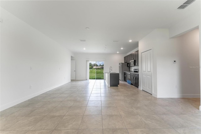 unfurnished living room featuring sink and light tile patterned floors