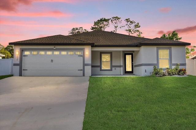 prairie-style home with a garage and a yard