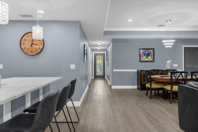 dining area featuring ornamental molding and hardwood / wood-style flooring