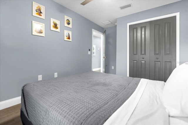 bedroom with a closet, dark hardwood / wood-style floors, and ceiling fan