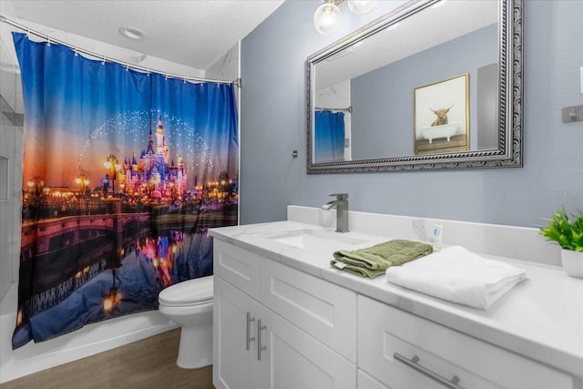 bathroom with vanity, hardwood / wood-style flooring, a shower with shower curtain, toilet, and a textured ceiling