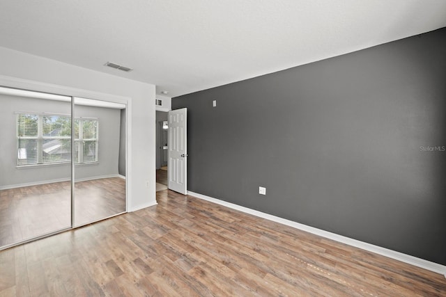 unfurnished bedroom featuring light wood-type flooring and a closet