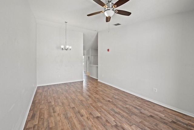 empty room featuring ceiling fan with notable chandelier, hardwood / wood-style flooring, and lofted ceiling