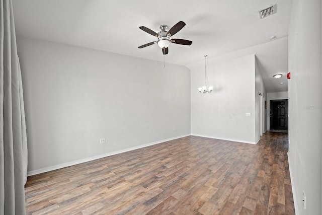 spare room with ceiling fan with notable chandelier, vaulted ceiling, and hardwood / wood-style flooring