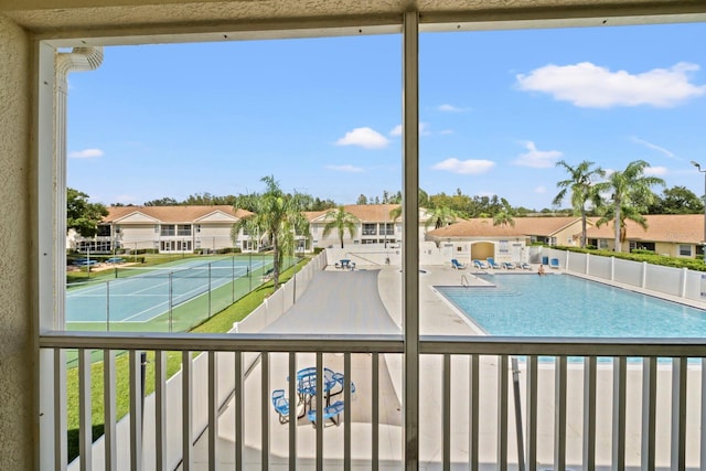 view of swimming pool with tennis court