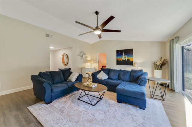 living room featuring hardwood / wood-style floors, vaulted ceiling, and ceiling fan