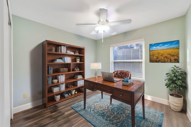 home office with dark hardwood / wood-style flooring and ceiling fan