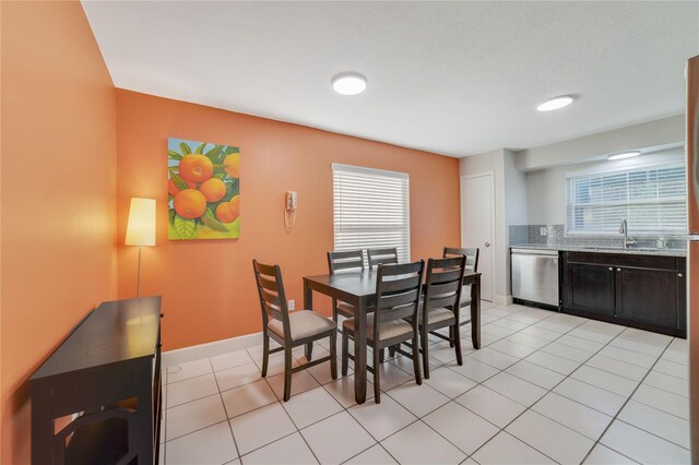 dining area with light tile patterned flooring, a healthy amount of sunlight, and sink