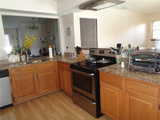 kitchen featuring light stone counters, sink, appliances with stainless steel finishes, and light hardwood / wood-style flooring