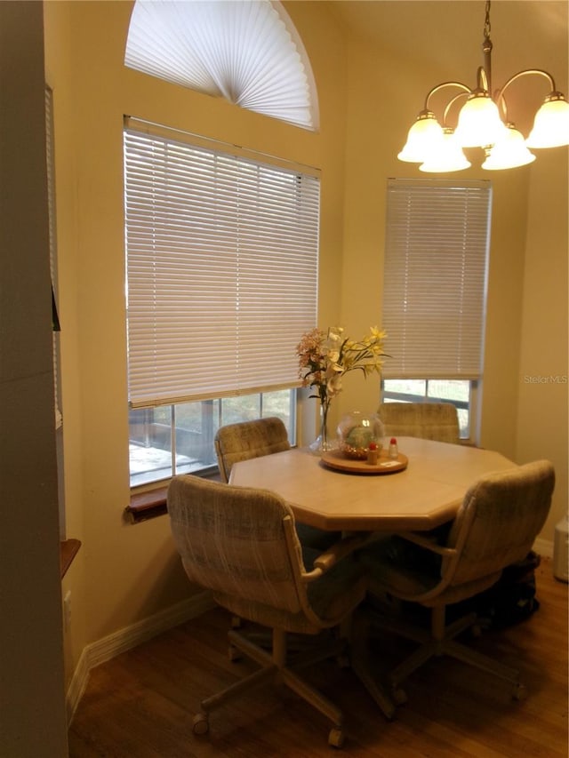 dining area with wood-type flooring and a notable chandelier