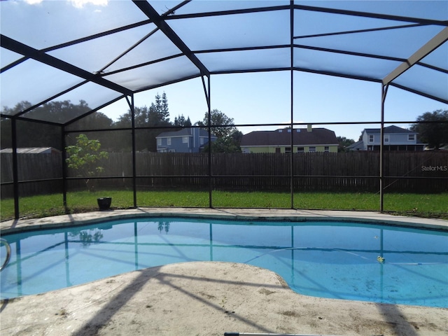 view of pool with a lanai and a lawn