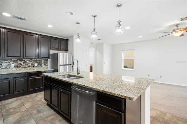 kitchen featuring appliances with stainless steel finishes, a kitchen island with sink, pendant lighting, and sink