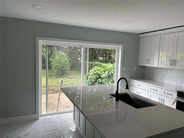 kitchen featuring white cabinetry, a wealth of natural light, and sink