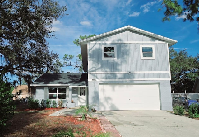 traditional home featuring an attached garage, fence, concrete driveway, and brick siding