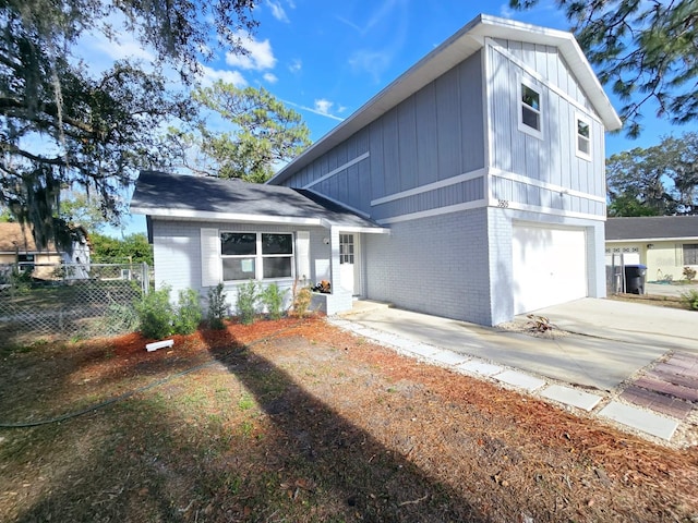 view of front facade featuring a garage, concrete driveway, brick siding, and fence