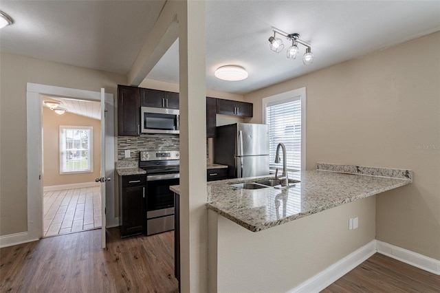 kitchen with stainless steel appliances, sink, plenty of natural light, and dark hardwood / wood-style flooring