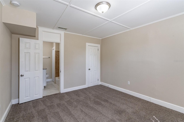 unfurnished bedroom featuring ensuite bathroom and carpet flooring