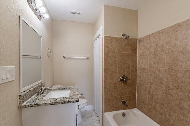 full bathroom featuring toilet, tiled shower / bath, and vanity