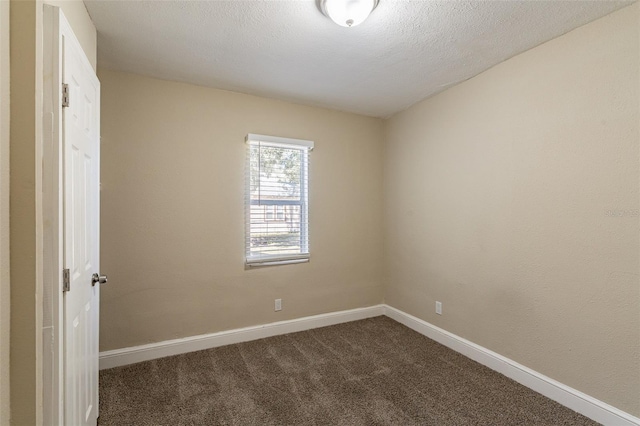 carpeted spare room featuring a textured ceiling