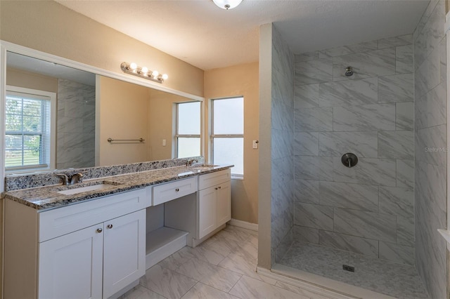 bathroom featuring vanity, a textured ceiling, and tiled shower