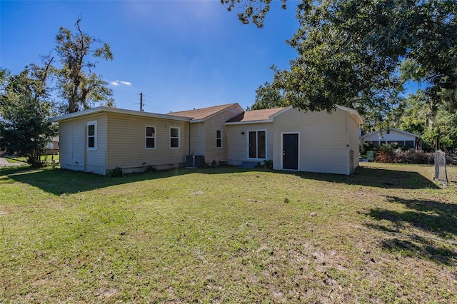 back of property with a lawn and cooling unit