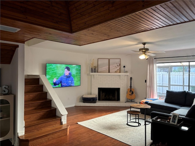 living room with a fireplace, wood-type flooring, ceiling fan, and wood ceiling