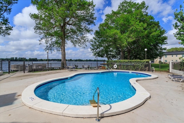 pool with a patio and fence