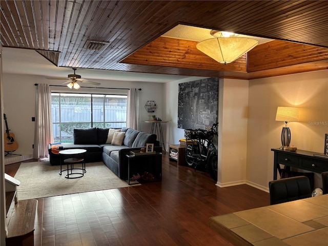 living room featuring baseboards, wood finished floors, and wooden ceiling