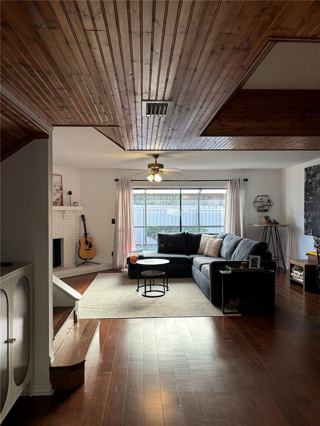 living room featuring visible vents, wood ceiling, dark wood finished floors, and a fireplace