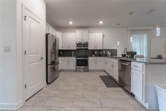 kitchen with tasteful backsplash, light tile patterned floors, white cabinetry, pendant lighting, and stainless steel appliances