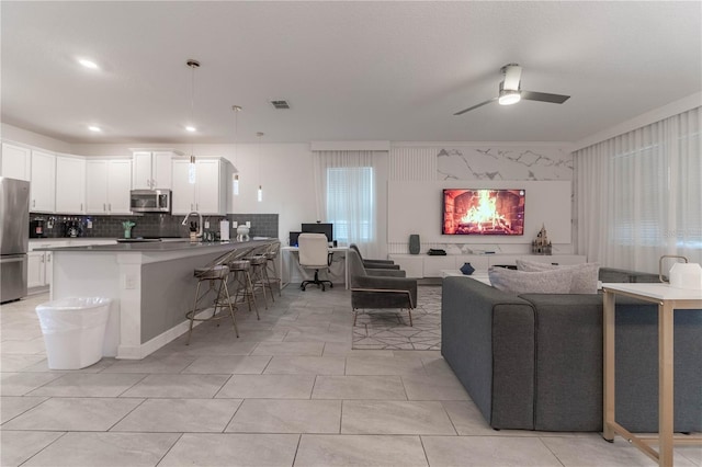 tiled living room with a healthy amount of sunlight and ceiling fan