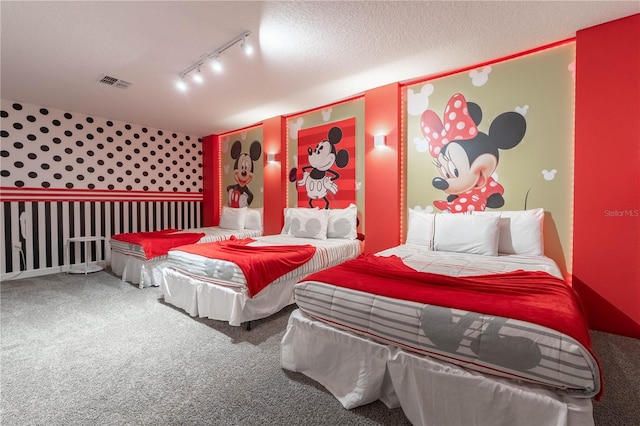 bedroom featuring carpet floors, a textured ceiling, and rail lighting