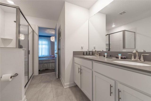 bathroom featuring vanity, a textured ceiling, tile patterned flooring, and a shower with door