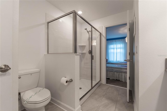 bathroom with toilet, a textured ceiling, a shower with shower door, and tile patterned flooring