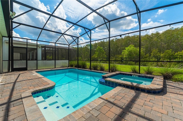 view of swimming pool featuring a patio area, a lanai, and an in ground hot tub