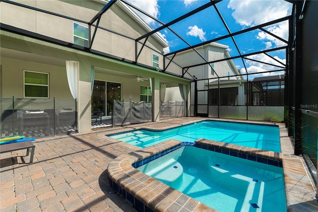 view of swimming pool featuring an in ground hot tub, ceiling fan, a patio, and a lanai