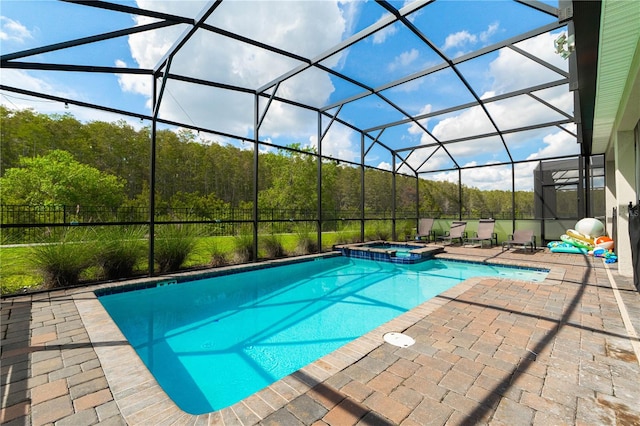 view of swimming pool with an in ground hot tub, a patio, and glass enclosure