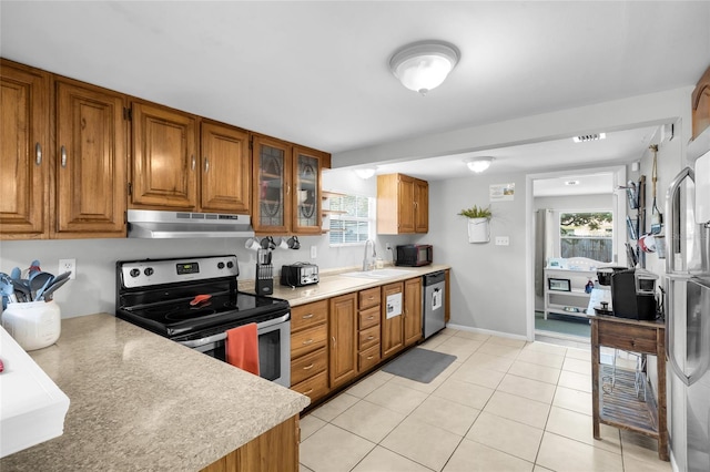5080 Seminole Ave, Winter Park, FL 32792 - kitchen featuring stainless steel appliances, under cabinet range hood, brown cabinets, a sink, and light countertops
