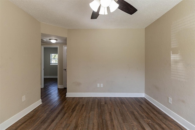 empty room with a textured ceiling, dark hardwood / wood-style floors, and ceiling fan