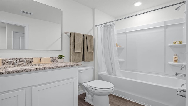 full bathroom with hardwood / wood-style floors, shower / bath combo, vanity, and toilet