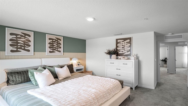 bedroom with light colored carpet and a textured ceiling