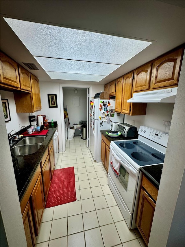 kitchen with white appliances, light tile patterned floors, and sink