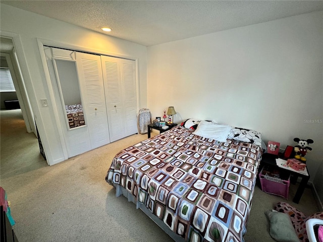 carpeted bedroom featuring a closet and a textured ceiling