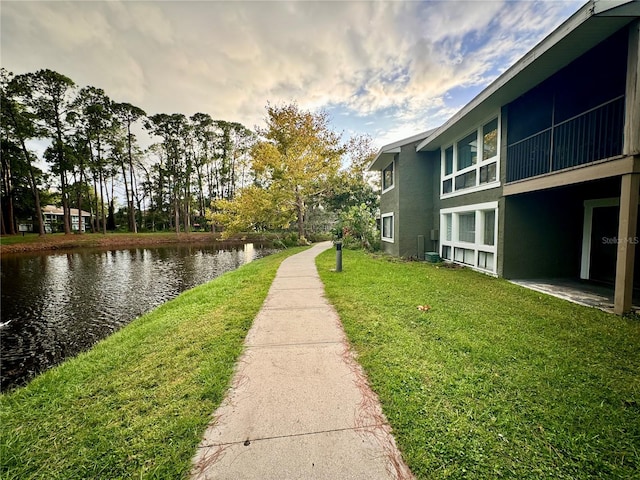 view of home's community featuring a water view and a lawn